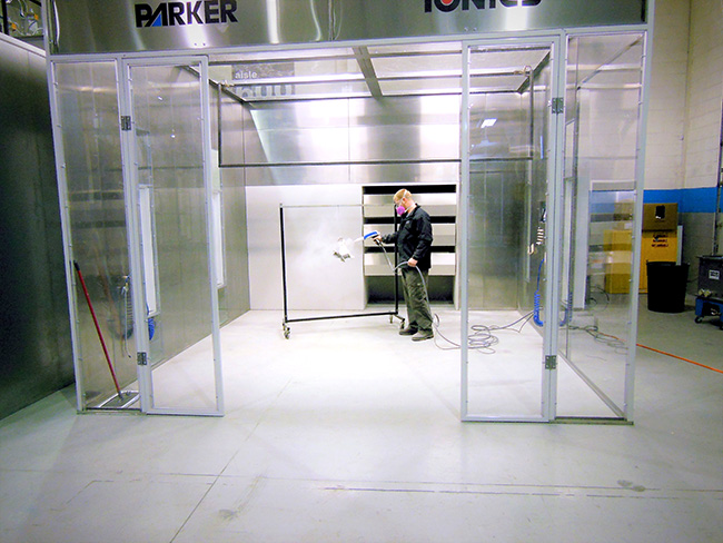 a man powder coats in a powder coating booth from Parker Ionics