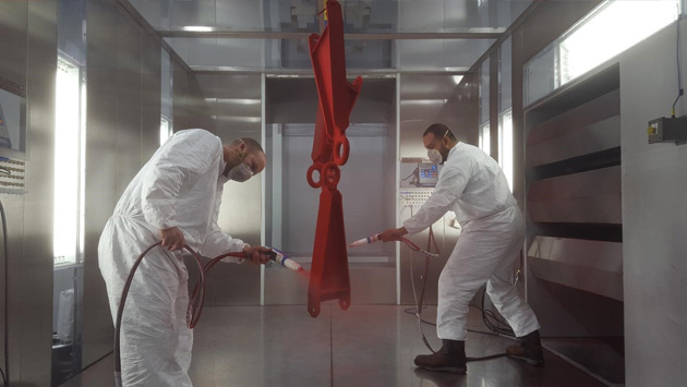 two men using powder coating equipment